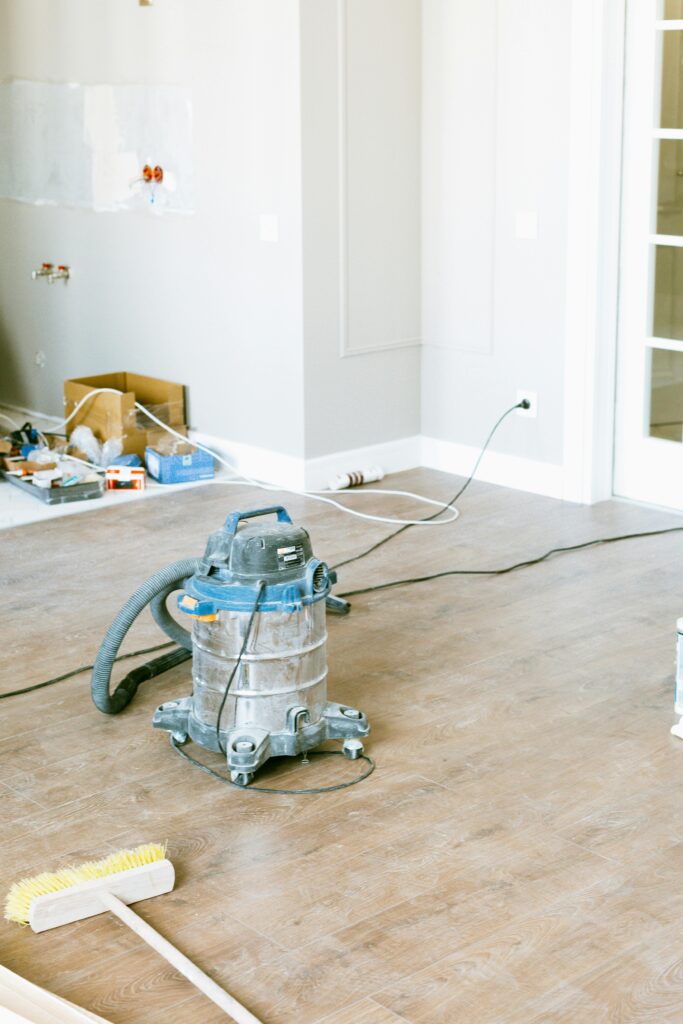 Vacuum and tools in a room undergoing renovation, showcasing home improvement.